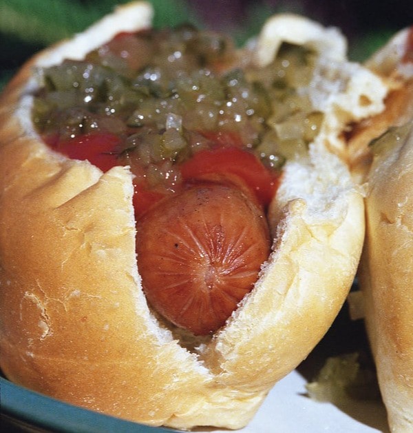 hot dog in bun with relish and ketchup